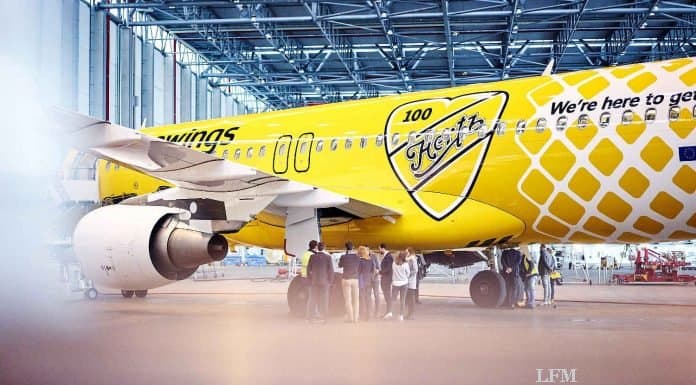 Gelbes Flugzeug von Eurowings fliegt mit Hertz