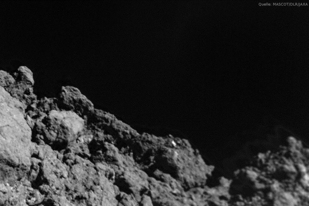 Oberfläche Ryugus aus wenigen Metern Entfernung: Die etwa 20 Bilder, die mit der Kamera MASCAM auf dem MASCOT-Lander während des Abstiegs aufgenommen wurden, zeigen eine extrem zerklüftete, von zahlreichen kantigen Gesteinsbrocken übersäte Oberfläche. Ryugu, ein viereinhalb Milliarden Jahre alter erdbahnkreuzender Asteroid der kohlenstoffreichen C-Klasse, zeigt den Wissenschaftlern ein Antlitz, das sie so nicht erwartet hatten, obwohl schon mehr als ein Dutzend Asteroiden von Raumsonden aus der Nähe erkundet wurden. Auf dieser Nahaufnahme sind keinerlei Flächen zu sehen, die von Staub bedeckt sind, dem Regolith, der durch die Zertrümmerung von Gestein infolge der Ausgesetztheit gegenüber Mikrometeoriten und energiereicher kosmischer Partikel über Milliarden von Jahren entsteht. Das Bild aus dem turbulent sich drehenden MASCOT-Lander entstand aus einer Höhe von etwa zehn bis zwanzig Metern.