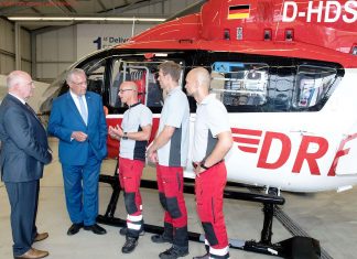 V.l.n.r.: Dr. Peter Huber (Vorstand DRF Luftrettung) und Joachim Herrmann (Innenminister Bayern) im Gespräch mit Notarzt Dr. Andreas Beyer, Pilot Sascha Netzer und Notfallsanitäter Andreas Adams. Die Tabelle zeigt die Einsatzzahlen der Rettungshubschrauber in Bayern