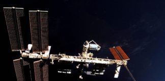 ISS und Columbus-Labor vor der unbeleuchteten Erde: Die Internationale Raumstation ISS schwebt über der Nachtseite. In blau erscheint am rechten Bildrand der beleuchtete Teil der Erde. In der Bildmitte ist das europäische Columbus-Labor, als hell glänzende Tonne zu erkennen, das im Februar 2008 an der ISS montiert wurde.