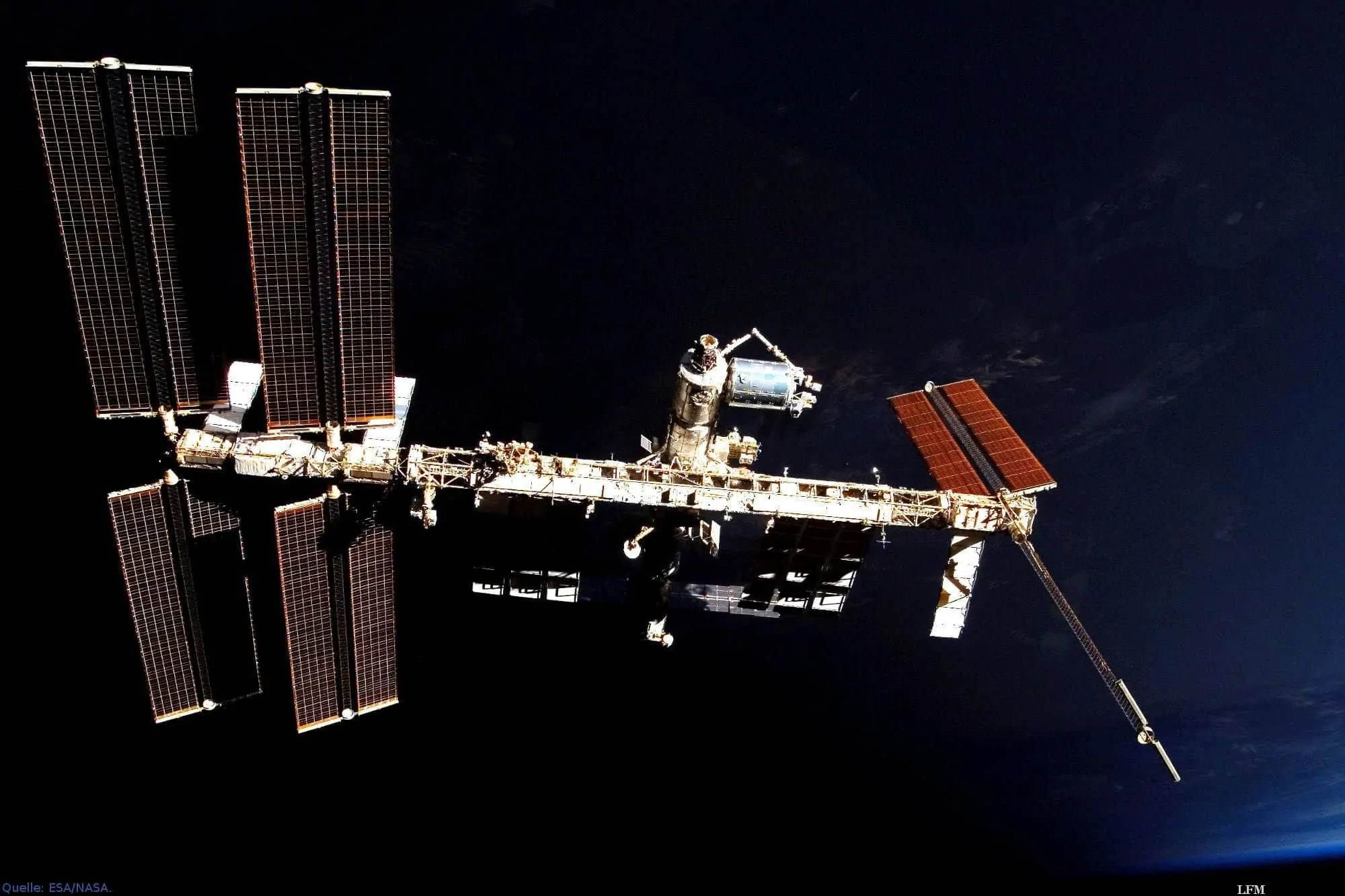 ISS und Columbus-Labor vor der unbeleuchteten Erde: Die Internationale Raumstation ISS schwebt über der Nachtseite. In blau erscheint am rechten Bildrand der beleuchtete Teil der Erde. In der Bildmitte ist das europäische Columbus-Labor, als hell glänzende Tonne zu erkennen, das im Februar 2008 an der ISS montiert wurde.