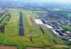 Luftbild mit Blick auf das Flughafengelände, inkl. Start- und Landebahn (SL-Bahn) und Terminalgebäude am Dortmund Airport.