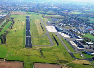 Luftbild mit Blick auf das Flughafengelände, inkl. Start- und Landebahn (SL-Bahn) und Terminalgebäude am Dortmund Airport.