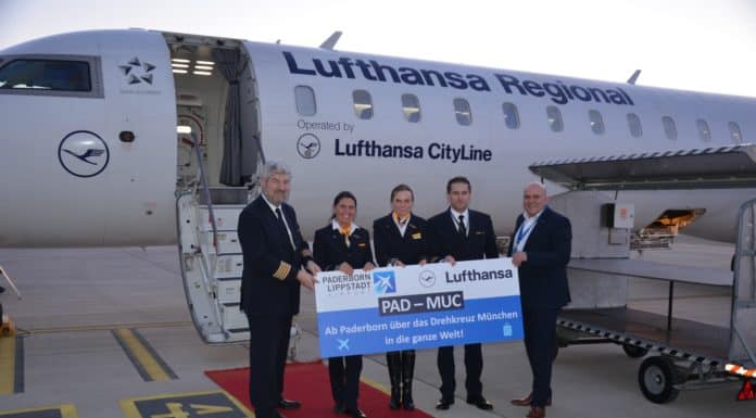 Lufthansa fliegt wieder ab Flughafen Paderborn/Lippstadt nach München Flugkapitän Andreas Leyerer (links), Crew-Mitglieder (Mitte), Flughafen-Geschäftsführer Roland Hüser (rechts)