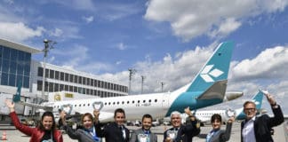 Die Airlinebetreuer Claudia Metschnabl (links) und Michael Haeffner (rechts) von der Flughafen München GmbH formierten sich vor dem Jubiläumsflug nach Venedig zusammen mit der Crew zum Gruppenbild.