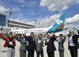 Die Airlinebetreuer Claudia Metschnabl (links) und Michael Haeffner (rechts) von der Flughafen München GmbH formierten sich vor dem Jubiläumsflug nach Venedig zusammen mit der Crew zum Gruppenbild.