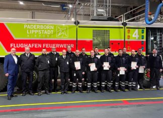 Flughafen-Geschäftsführer Roland Hüser, Kreisbrandmeister Elmar Keuter, Leitstellen-Leiter Tobias Starke, Rettungsdienst-Leiter Stefan Kaiser und der Ärztliche Leiter des Rettungsdienstes Ingo Christiansen (von links) gratulieren einigen Teilnehmern mit dem Leiter der Flughafen-Feuerwehr Roland Kempkensteffen (rechts) zur erfolgreichen Ausbildung als Notfallhelfer NRW.
