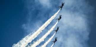 5 kleine Flugzeuge im Himmel, die im Rahmen einer Kunstflugshow fliegen