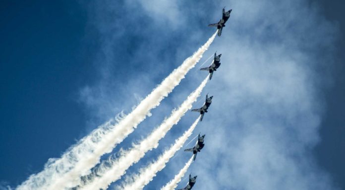 Die Geschichte und Entwicklung des Luftsports rund um die Welt 5 kleine Flugzeuge im Himmel, die im Rahmen einer Kunstflugshow fliegen