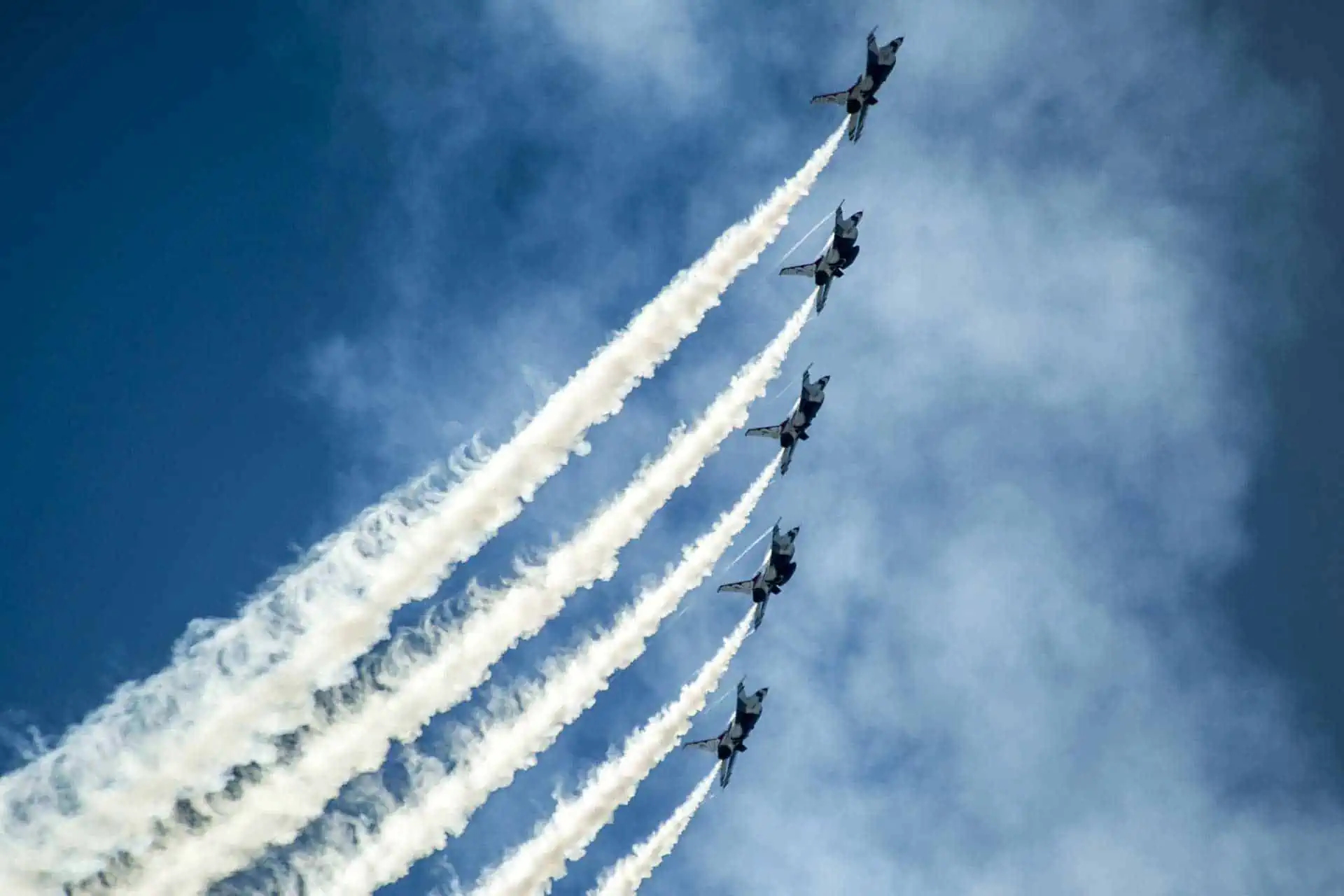 5 kleine Flugzeuge im Himmel, die im Rahmen einer Kunstflugshow fliegen
