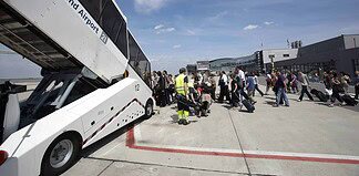 Passagiere auf dem Vorfeld des Dortmund Airport, beim Einstieg in ein Flugzeug.