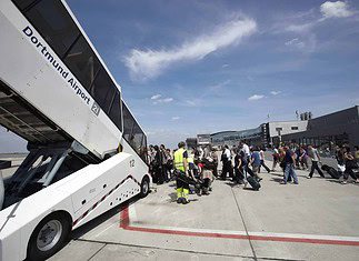 Passagiere auf dem Vorfeld des Dortmund Airport, beim Einstieg in ein Flugzeug.