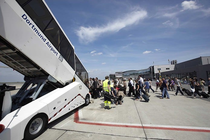 Passagiere auf dem Vorfeld des Dortmund Airport, beim Einstieg in ein Flugzeug.