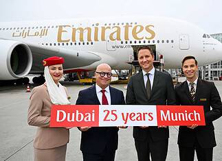Emirates feiert 25 Jahre am Flughafen München: Joachim Sobottka-Rogalla, Emirates Airport Services Manager Munich (links), und Oliver Dersch, Senior Vice President Aviation, Flughafen München - flankiert von Mitgliedern der Emirates Kabinencrew.