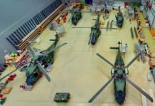 Several military helicopters are parked in a hangar