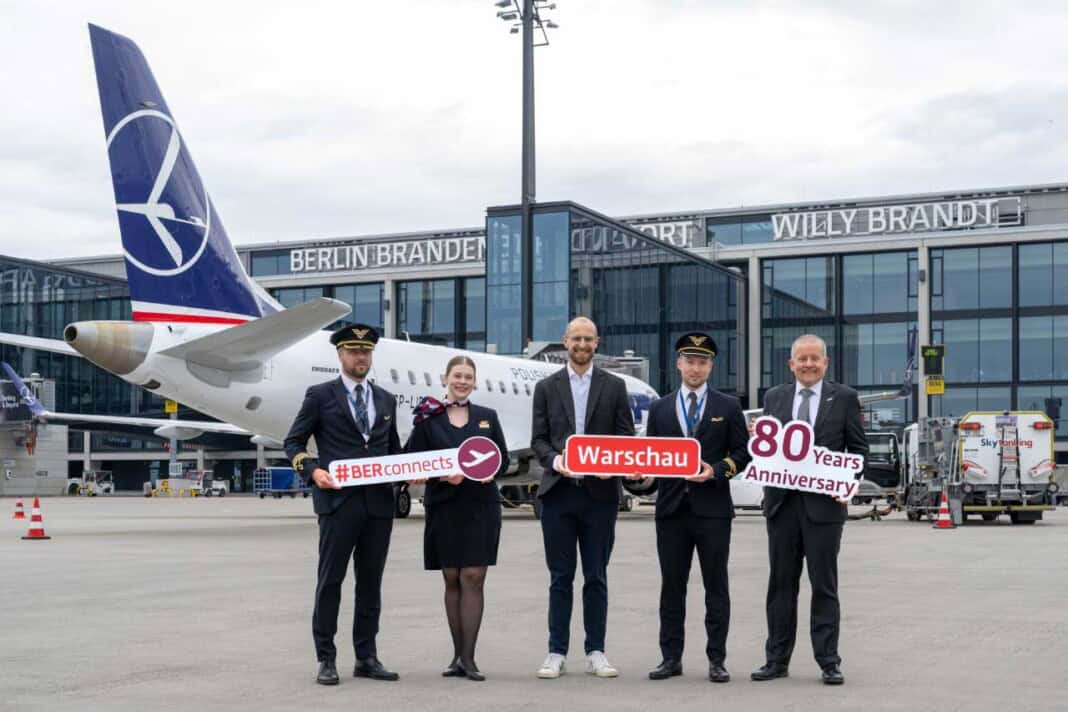 Johannes Mohrmann, Senior Manager Business Development Aviation, Flughafen Berlin Brandenburg GmbH (Mitte) und Udo Clemens, Inside Sales Manager DACH/Italy/Malta, LOT Polish Airlines (1.v.r.) inmitten von Crew.