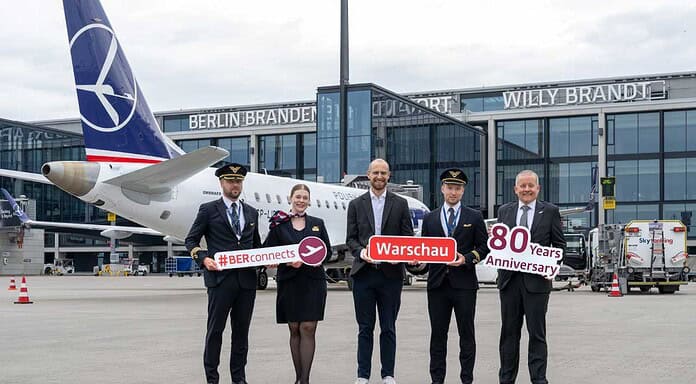 Johannes Mohrmann, Senior Manager Business Development Aviation, Flughafen Berlin Brandenburg GmbH (center), and Udo Clemens, Inside Sales Manager DACH/Italy/Malta, LOT Polish Airlines (far right), amidst the crew.