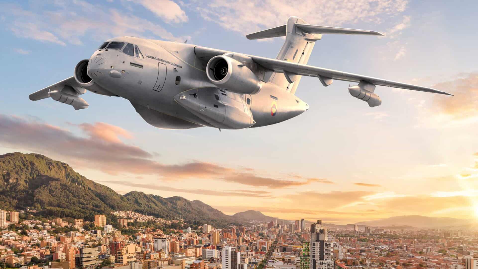 Aerial view of an Embraer KC-390 in front of modern architecture in Bogotá, Colombia.