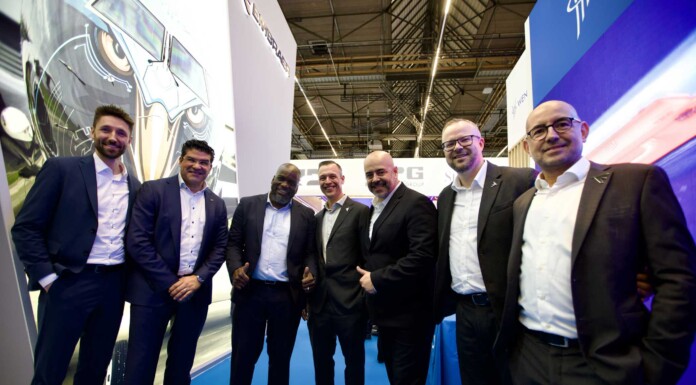 Cooperation between Embraer and Austrian Airlines: Optimizing E-Jet maintenance A group of executives in a trade fair setting, engaged in a collaboration within the aviation sector.