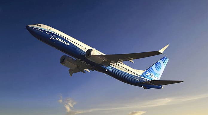 Boeing aircraft flies over a mountainous landscape