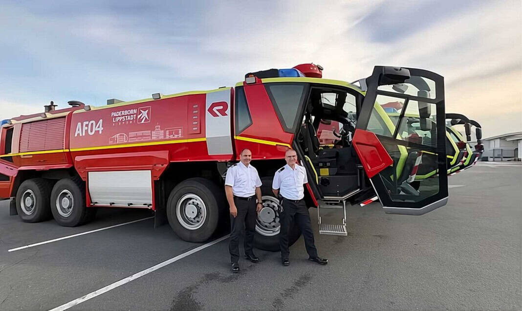 Der Leiter der Flughafen-Feuerwehr, Roland Kempkensteffen (links), und sein Stellvertreter Thorsten Bösch vor den Flugfeld-Löschfahrzeugen Rosenbauer PANTHER 8x8.